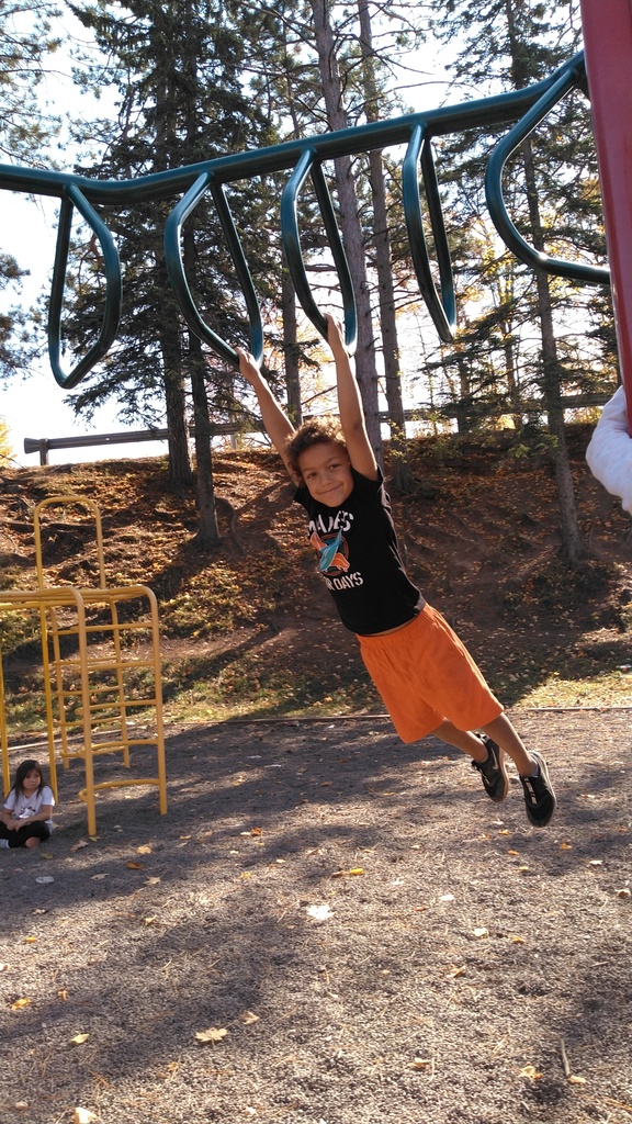 boy hanging on playground equipment
