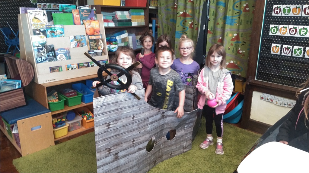 students playing in cardboard pirate ship