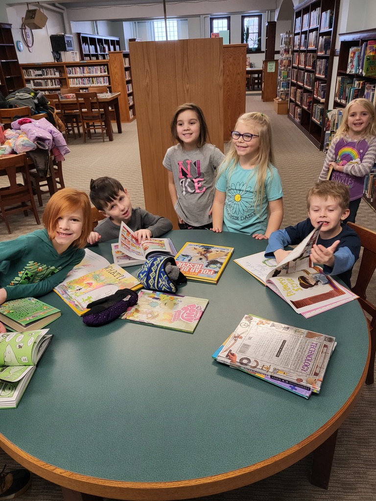 kindergarten students with books at the library
