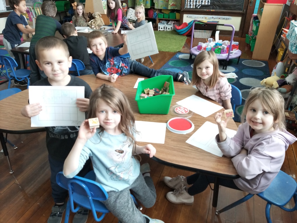 Kindergarten students using stamps  to learn numbers