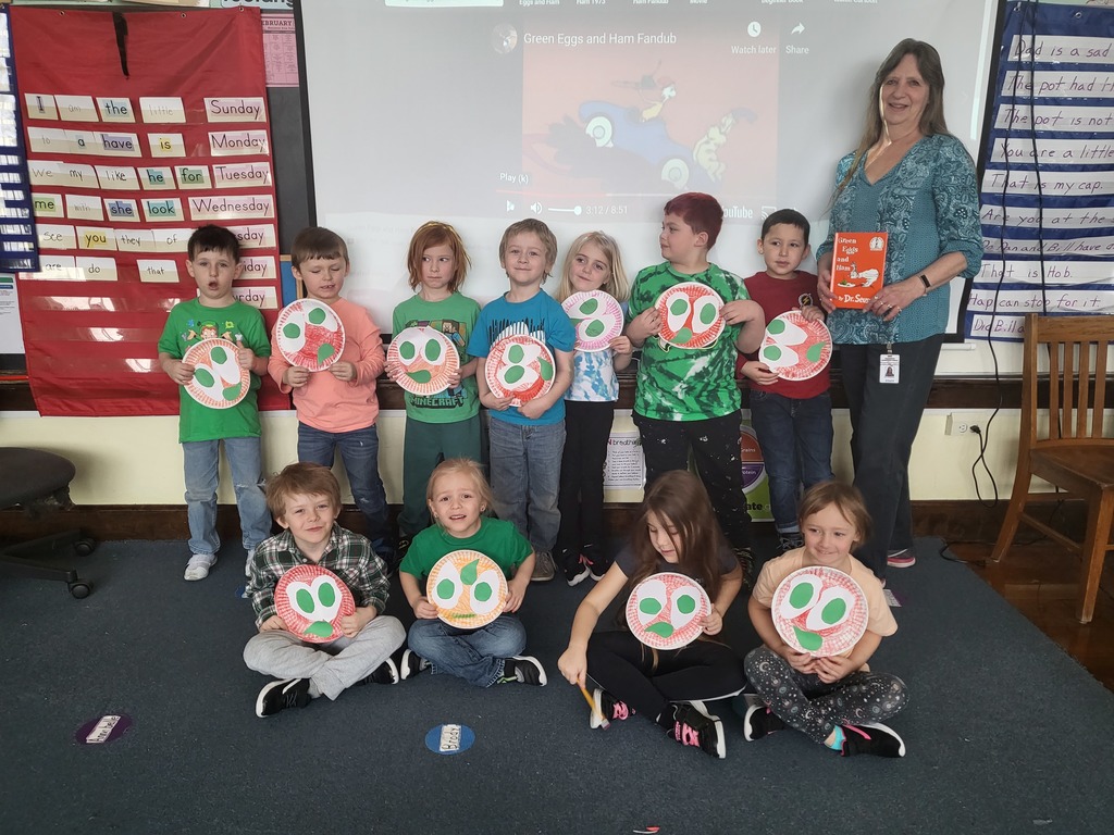 Students and teacher holding up Green Eggs and Ham craft