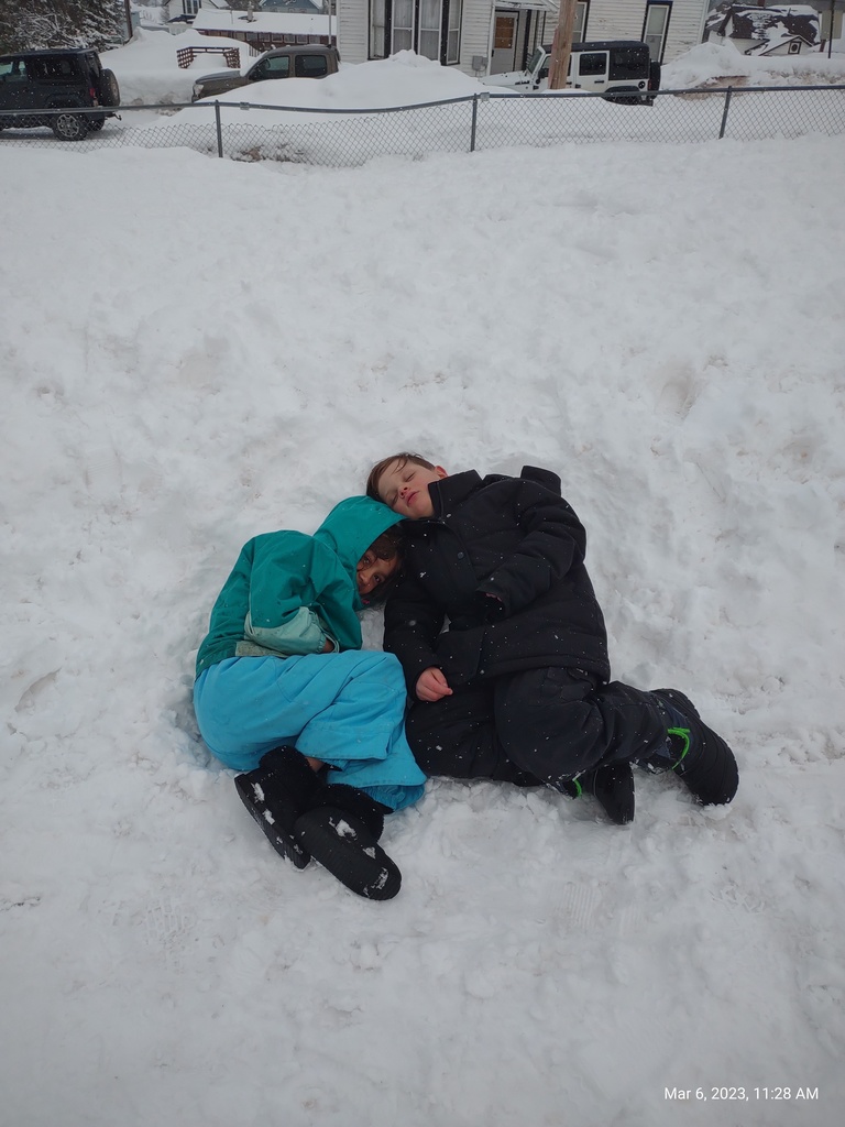 2 students laying down in snow