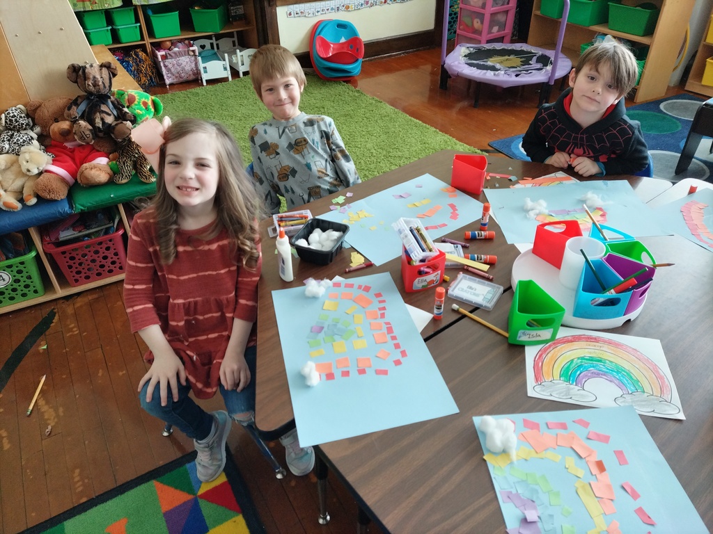 girl and two boys working on rainbow craft