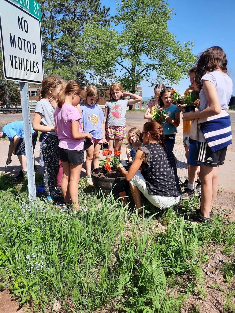 students and teacher planting flowers