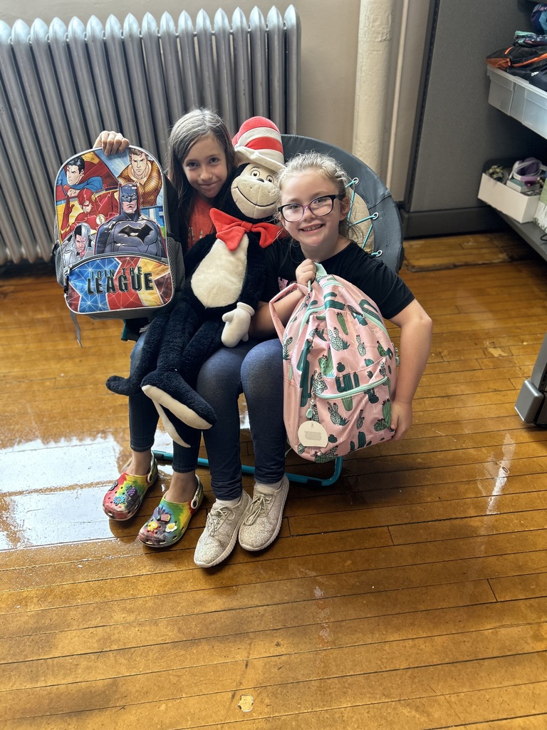 2 girls sitting in chair with Cat in the Hat stuffed animal
