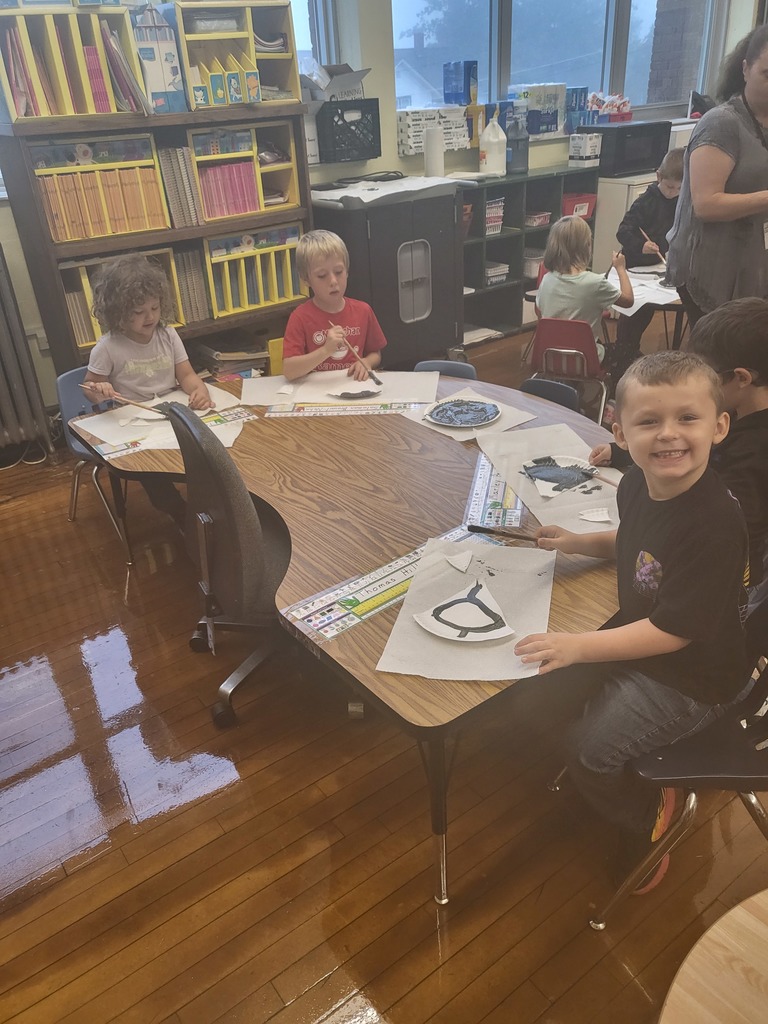 kindergarten boy, smiling while working on art project