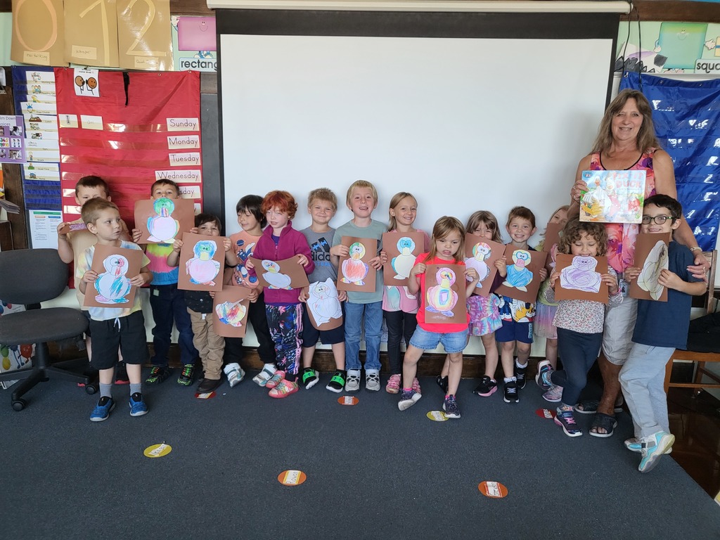 slass of kindergarten students holding duck artwork
